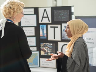 An ASP student gives a presentation to an adult onlooker.