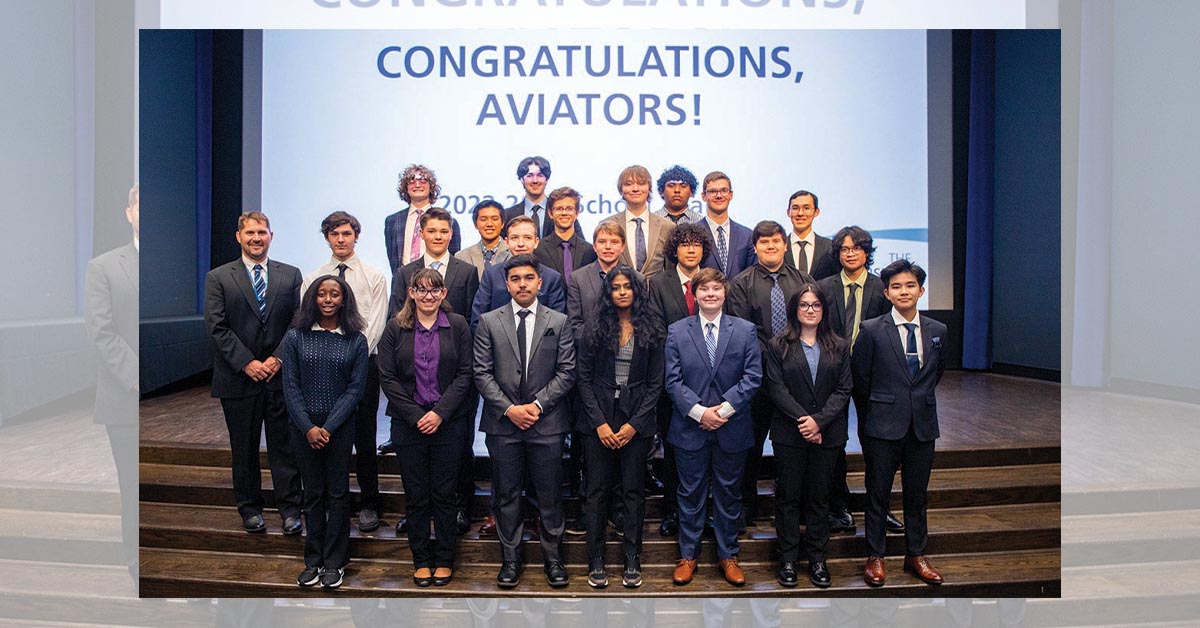 Featured image: Group of students in front of a projector screen that reads 